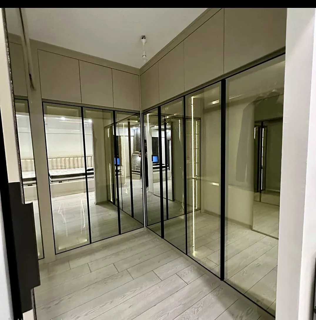 Modern L-shaped dressing room with glass doors, built by Woodify