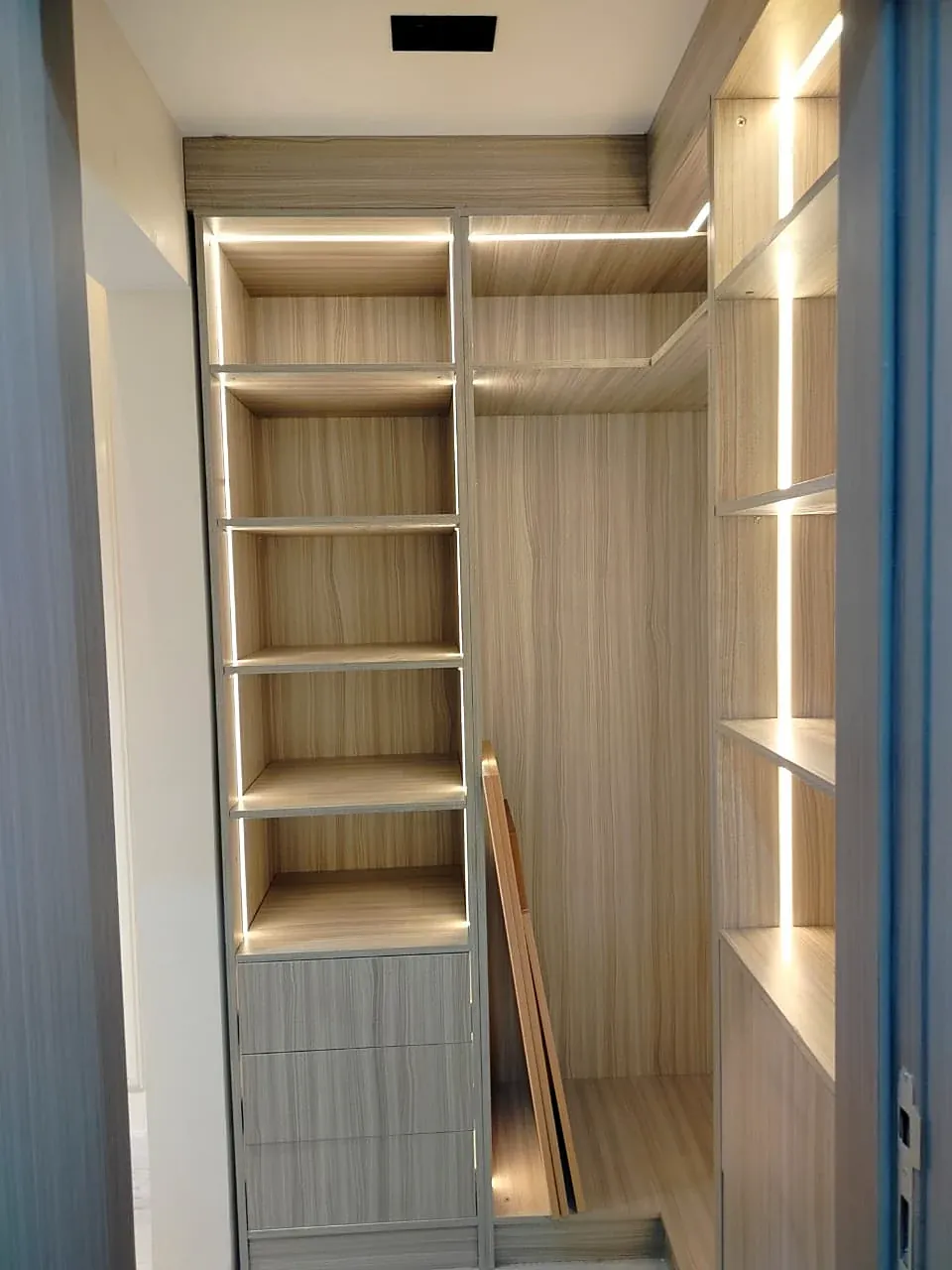 Open dressing room in a light wood finish with shelves and LED lighting, built by Woodify